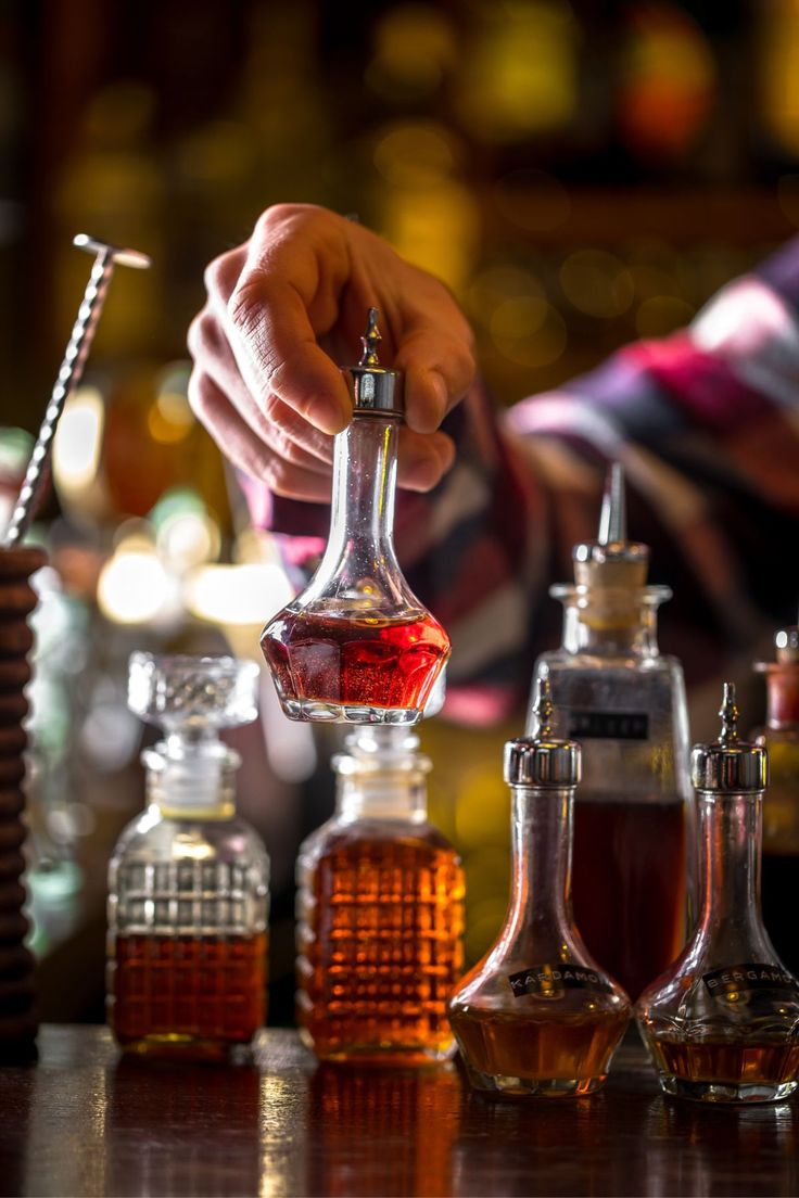 Bartender adding bitters to a cocktail glass