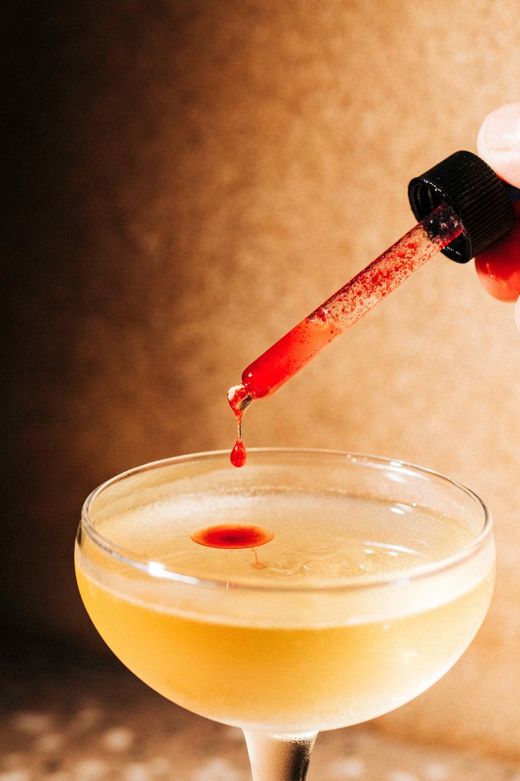 Bartender preparing a cocktail with bitters at an event
