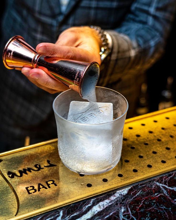 Bartender inspecting cocktail presentation with custom ice